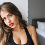 7closeup portrait ataddadng girl with long brunette hair modern apartment sexy t shirt true emotion red lips morning fashionable model relax